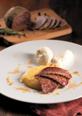 Teller mit Polenta und Scheiben der geräucherten Pitina 